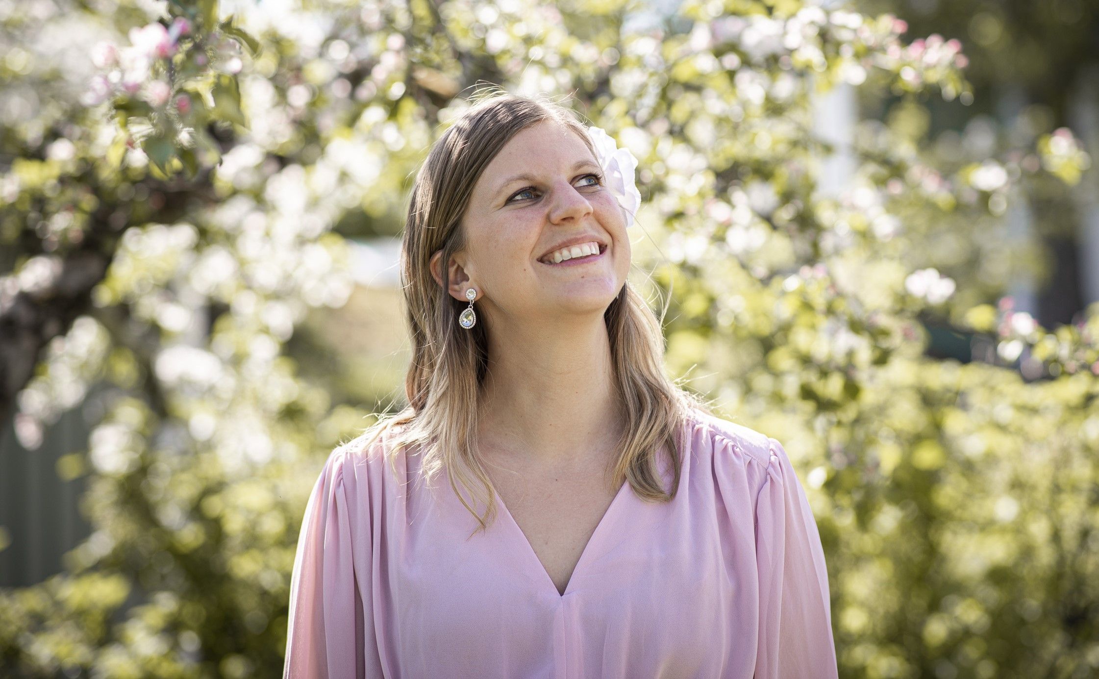 Amanda Carlsson smiling and looking pretty wearing a soft pink dress