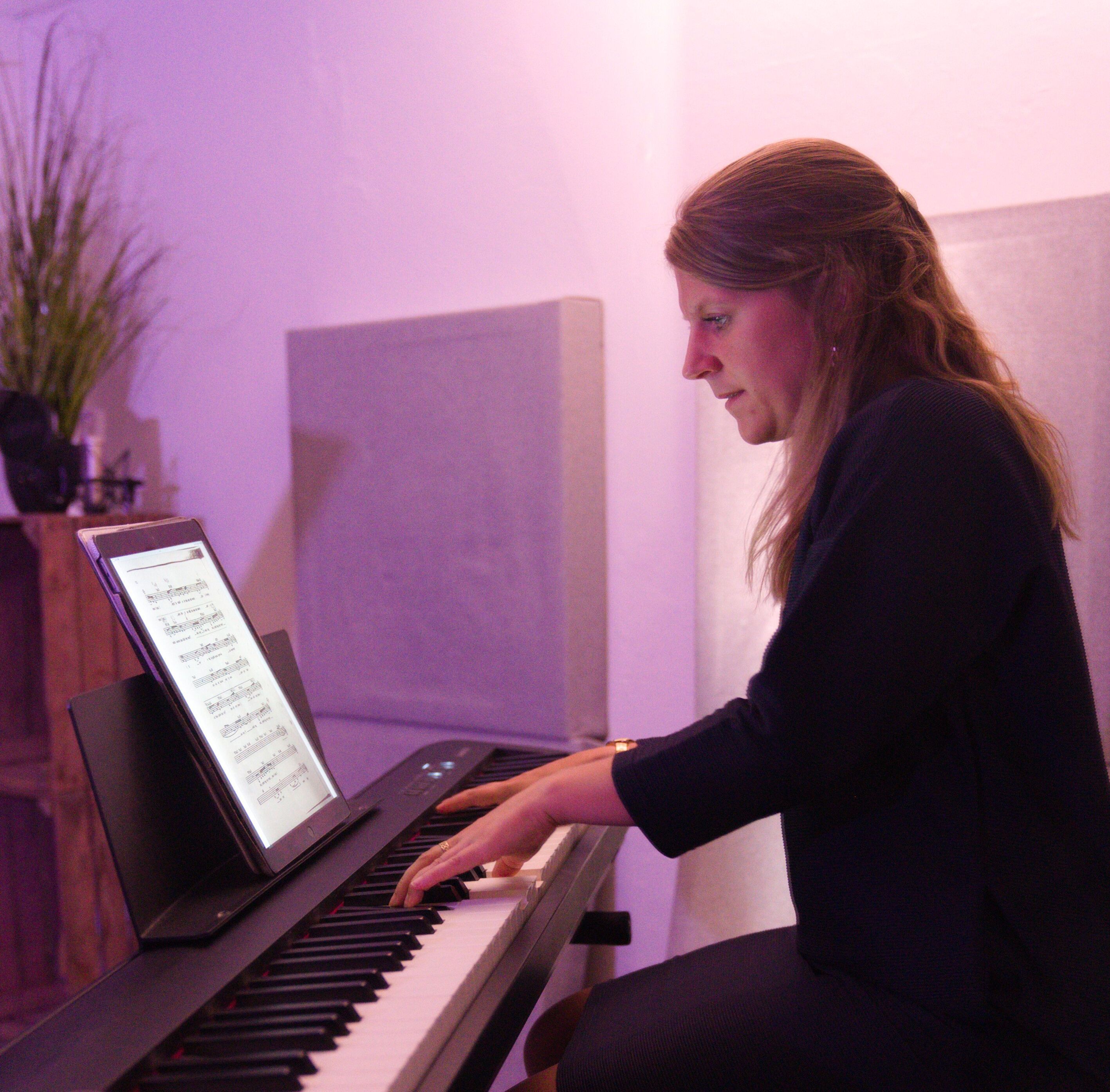 Amanda playing the piano for her singing student